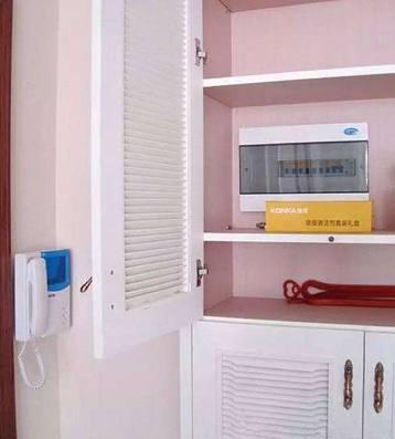 老電工把配電箱安裝在墻內。曬太陽太聰明了。